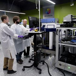 Automation scientist August Allen, technician Nick Campbell and biology technician David Compton work in the robotics lab at Recursion Pharmaceuticals in Salt Lake City on Wednesday, May 26, 2017.