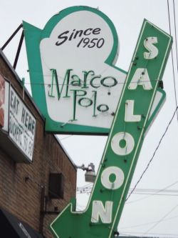 Exterior of Marco Polo, showing a retro green sign for the saloon.