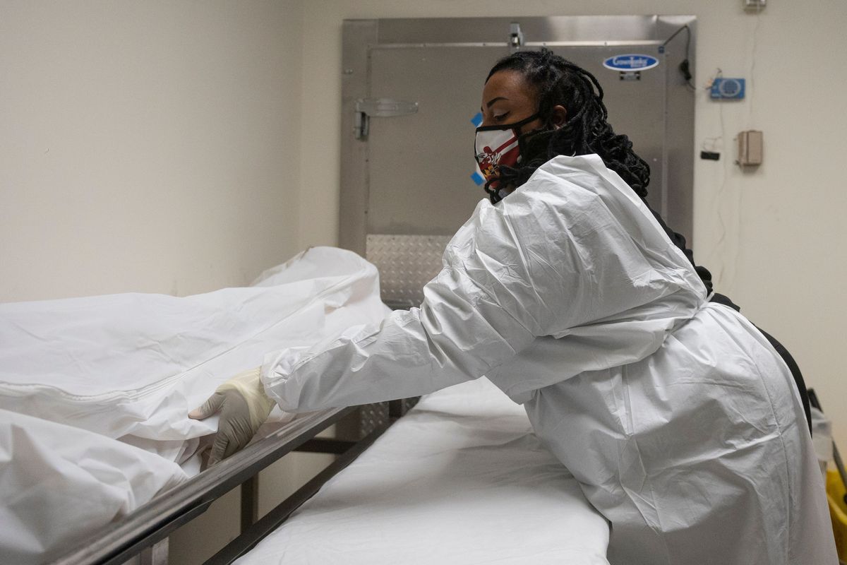 Funeral home transporter Morgan Dean-McMillan prepares to transport a suspected Covid-19 positive body in a hospital’s morgue in Baltimore, Maryland on December 23, 2020 during the Covid-19 pandemic.