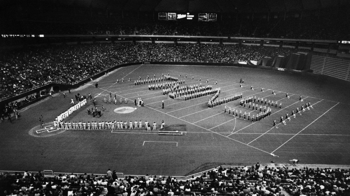 The marching band at the regular season opener at the Metrodome Tuesday night drew lines on the field with tape so it could spell out Twins. Photo by Tribune (now Star Tribune) staff photographer Neil McGahee. The Twins lost 11-7 to the Seattle Mariners
