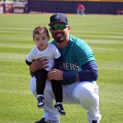Seattle Mariners catcher Jacob Nottingham warms up with his son Aiden Nottingham prior to the game against the Los Angeles Angels at Peoria Sports Complex.
