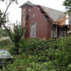Downed trees and a damaged roof are seen on the Portland United Methodist Church that was damaged Monday, June 22, 2015, in Portland, Mich. Five people were rescued from damaged buildings in Portland and thunderstorms packing strong winds caused damage in Iowa and Illinois as severe weather swept through parts of the Midwest on Monday. 
