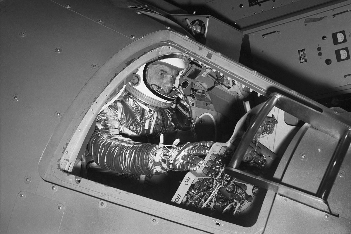 In this Jan. 11, 1961 file photo, Marine Lt. Col. John Glenn reaches for controls inside a Mercury capsule procedures trainer as he shows how the first U.S. astronaut will ride through space during a demonstration at the National Aeronautics and Space Administration Research Center in Langley Field, Va.