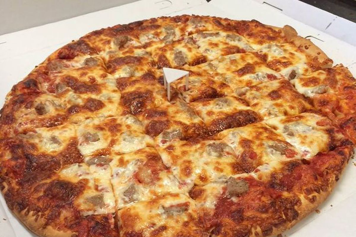 A pizza with lots of cheese cut into squares