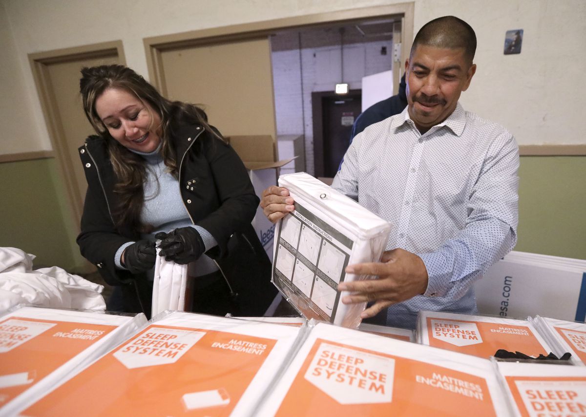 Charlotte Garcia and her fiancé, Ernie Luna, unwrap mattress covers at the Rescue Mission of Salt Lake on World Homeless Day in Salt Lake City on Wednesday, Oct. 10, 2018. Luna is a graduate of the mission's recovery program. Leesa Sleeps donated 150 matt