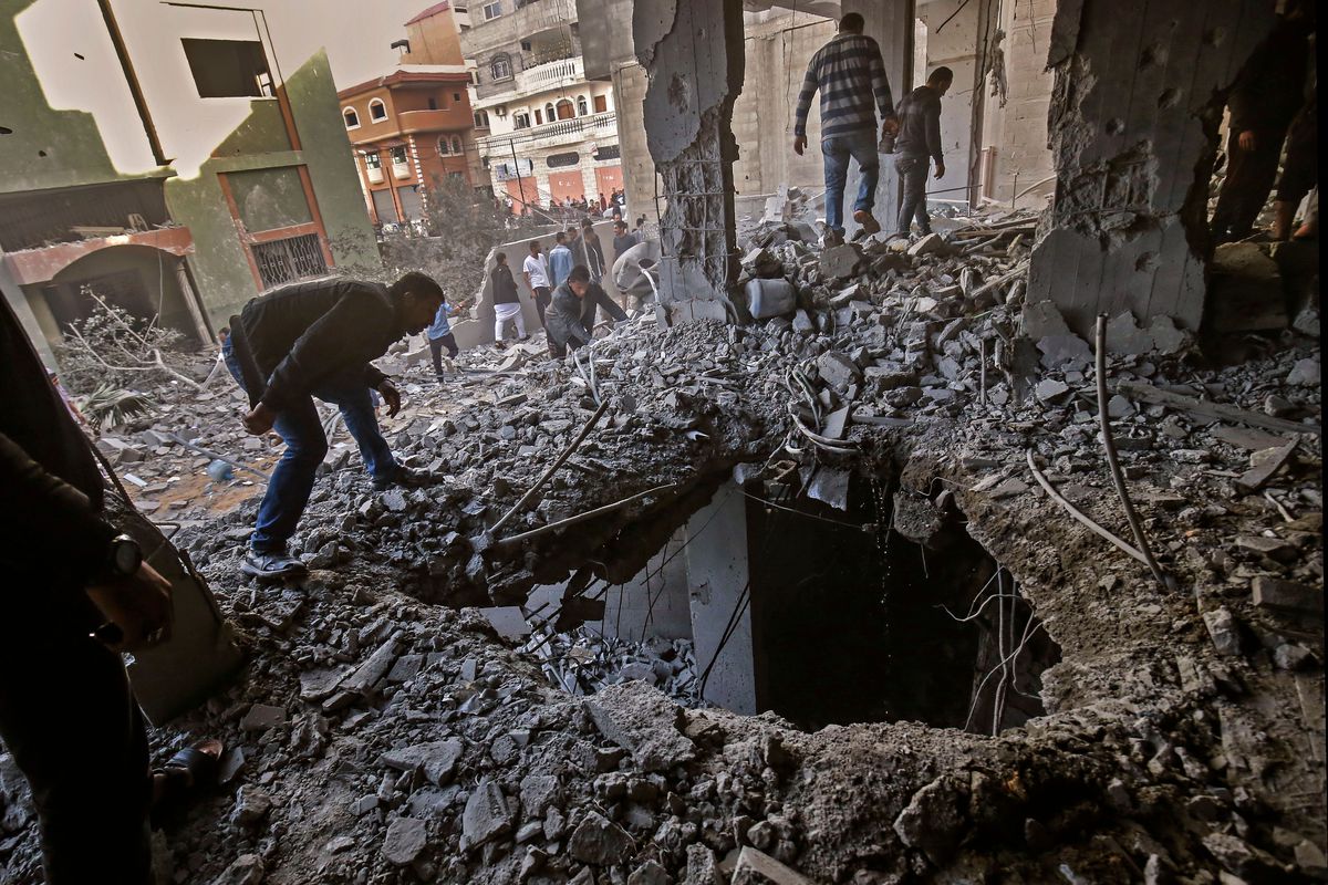 Palestinians walk through the rubble left by an Israeli airstrike. 
