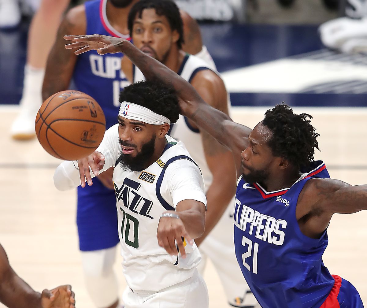 Utah Jazz guard Mike Conley (10) passes away from LA Clippers guard Patrick Beverley (21) as the Utah Jazz and LA Clippers play in an NBA basketball game at Vivint Smart Home Arena in Salt Lake City on Friday, Jan. 1, 2021. Utah won 106-100.