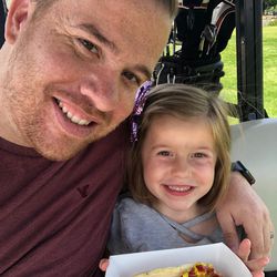 Kellen and Aria Hill enjoy a hot dog during one of their many golf outings together.