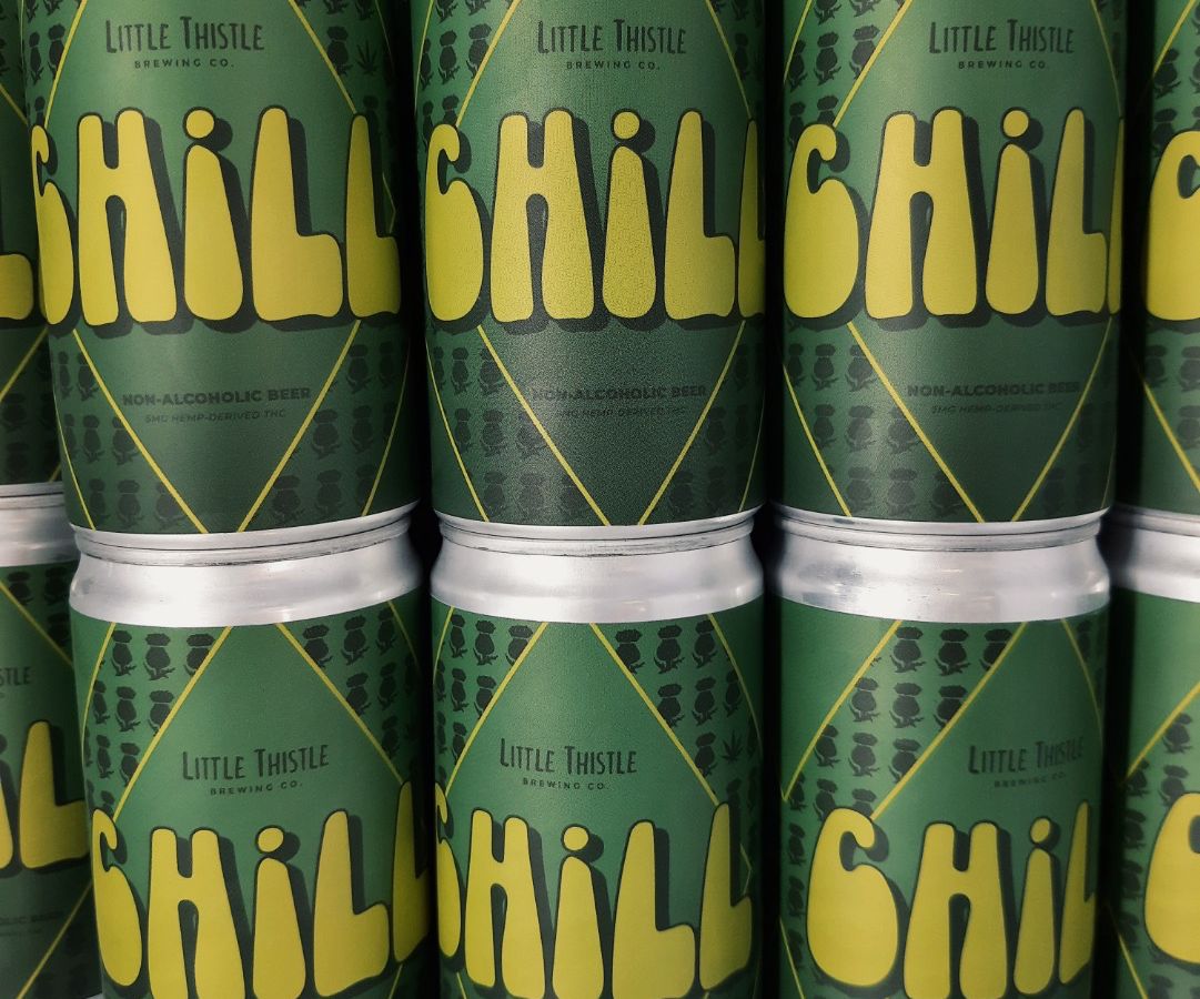 A row of cans with a green label reading “CHILL” on them stacked on top of one another.