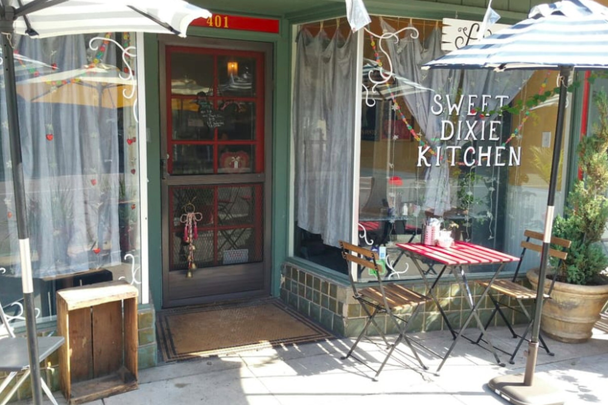 Sweet Dixie Kitchen’s restaurant exterior, with tables, in Long Beach.