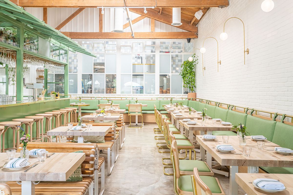 A dining room with light wood and mint green accents at the Butcher’s Daughter on Melrose.