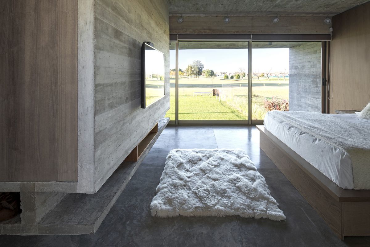 Bedroom with concrete floor and sheepskin rug.