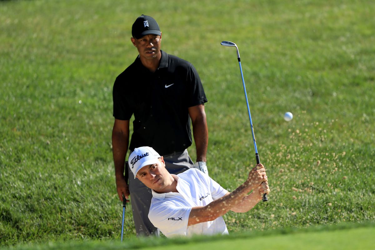 Tiger Woods watches Justin Thomas play a shot from the bunker during a practice round prior to The Memorial Tournament at Muirfield Village Golf Club on July 14, 2020 in Dublin, Ohio.