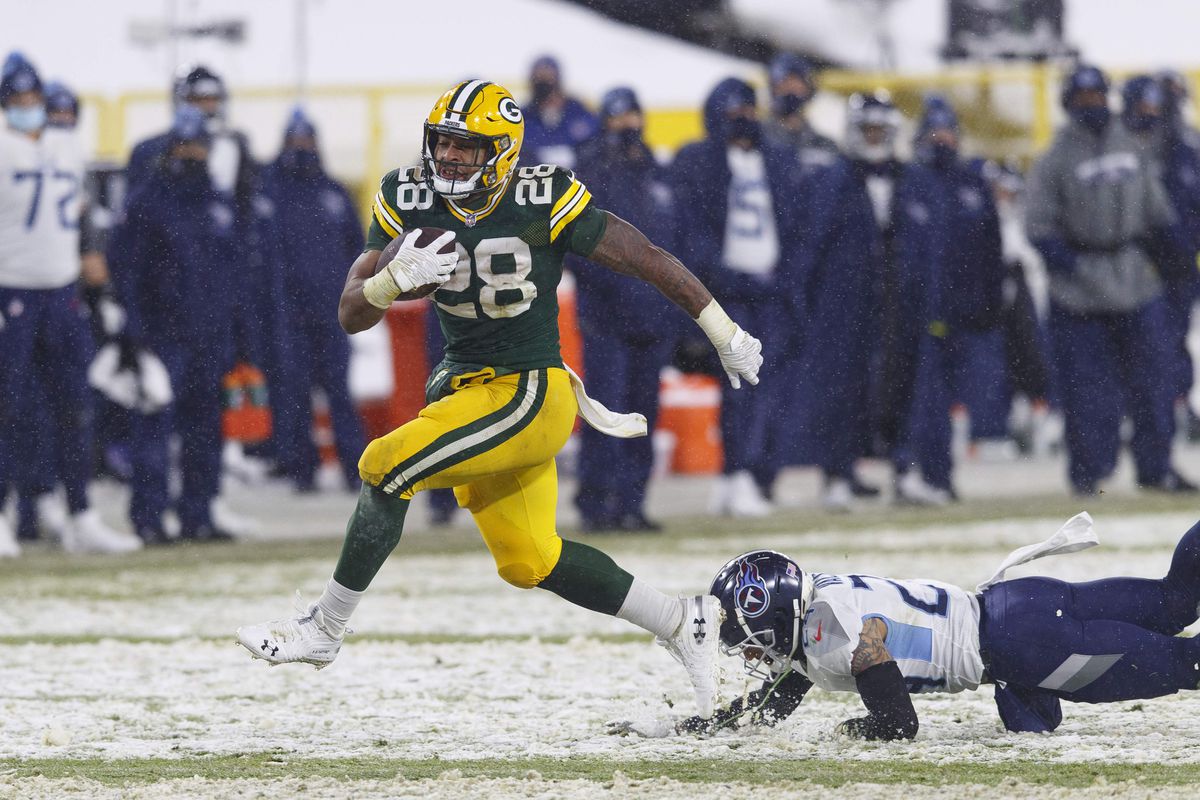 Green Bay Packers running back A.J. Dillon (28) rushes for a touchdown as Tennessee Titans safety Kenny Vaccaro (24) dives from behind during the third quarter at Lambeau Field.