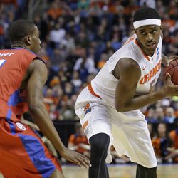 Syracuse's C.J. Fair (5) protects the ball from Dayton's Jordan Sibert (24) during the first half of a third-round game in the NCAA men's college basketball tournament in Buffalo, N.Y., Saturday, March 22, 2014. (AP Photo/Frank Franklin II)