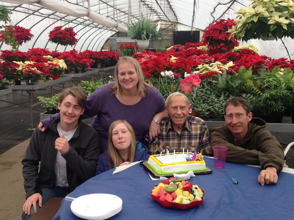 Henry Meinke (with cake) celebrating a birthday in his greenhouse with his son Jim, daughter-in-law Luanne and grandchildren Henry Colin and Sarah.