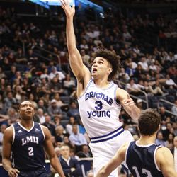 Brigham Young Cougars guard Elijah Bryant (3) finger rolls a shot in while being fouled by Loyola Marymount Lions forward Steven Haney (12) as the Brigham Young Cougars take on the Loyola Marymount Lions at the Marriott Center in Provo on Thursday, Jan. 18, 2018.