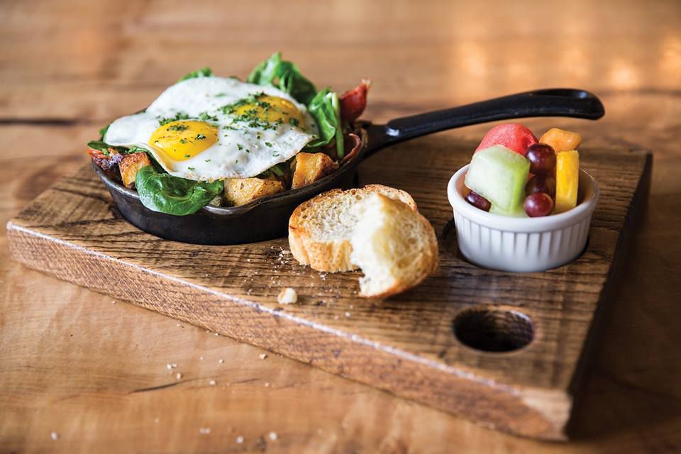 Skillet hash on a serving board with bread and fruit
