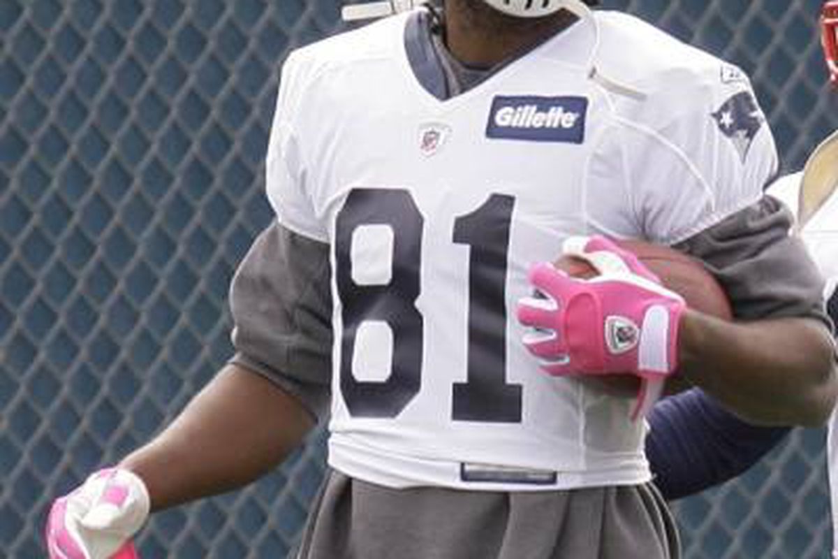 <em>Randy Moss wears pink gloves during Monday's practice in recognition of Breast Cancer Awareness week.</em>