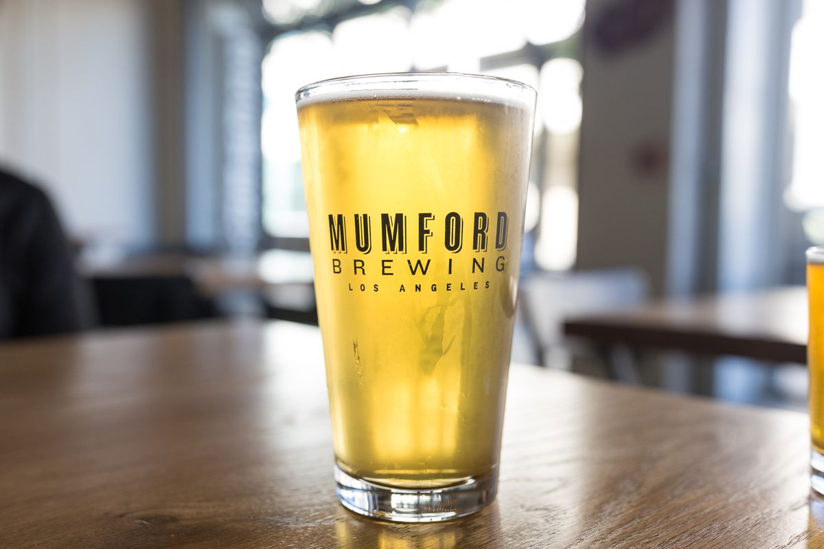A light lager, with sun shining through the pint glass at daytime, from Mumford Brewing.