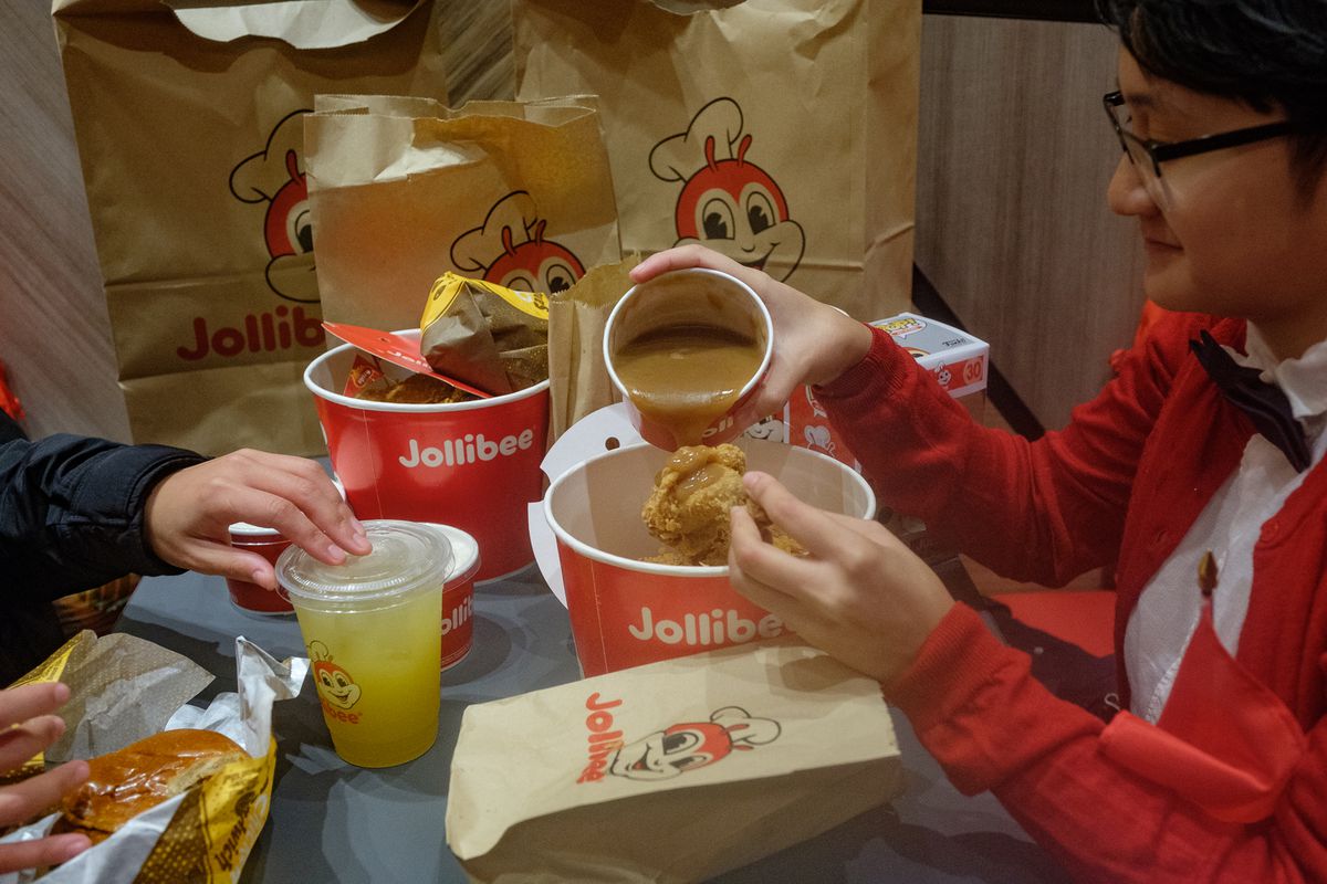 A Jollibee customer pours gravy on her Chickenjoy, a common use of the gravy.