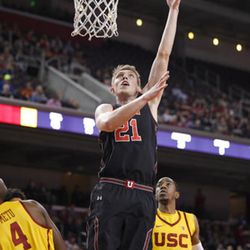 Utah forward Tyler Rawson, center, shoots as Southern California forward Chimezie Metu, left, and guard Shaqquan Aaron defend during the first half of an NCAA college basketball game Sunday, Jan. 14, 2018, in Los Angeles. (AP Photo/Mark J. Terrill)