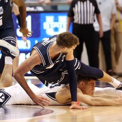 Brigham Young Cougars guard Alex Barcello (13) dives after a loose ball as Utah State Aggies forward Brandon Horvath (4) falls over him as BYU and Utah State play an NCAA basketball game in Provo at the Marriott Center on Wednesday, Dec. 8, 2021.