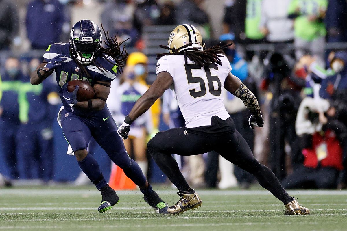 Alex Collins #41 of the Seattle Seahawks is pursued by Demario Davis #56 of the New Orleans Saints during the second half at Lumen Field on October 25, 2021 in Seattle, Washington.