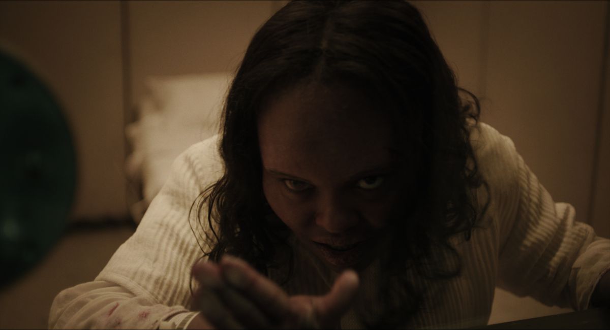 Lidya Jewett in The Exorcist: Believer standing close to a window making a face while possessed by a demon