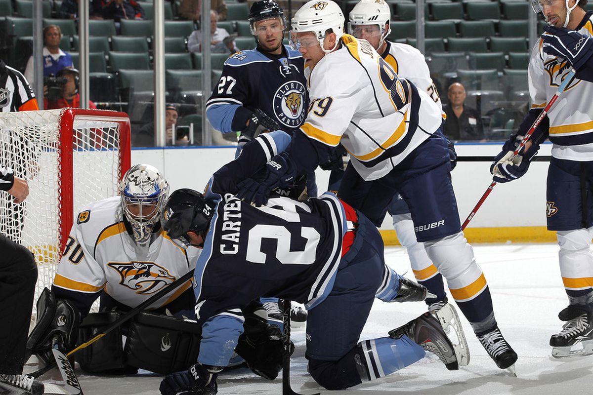 SUNRISE, FL - SEPTEMBER 19: Tyler Sloan #89 of the Nashville Predators checks Ryan Carter #24 of the Florida Panthers in front of the net on September 19, 2011 at the BankAtlantic Center in Sunrise, Florida. (Photo by Joel Auerbach/Getty Images)