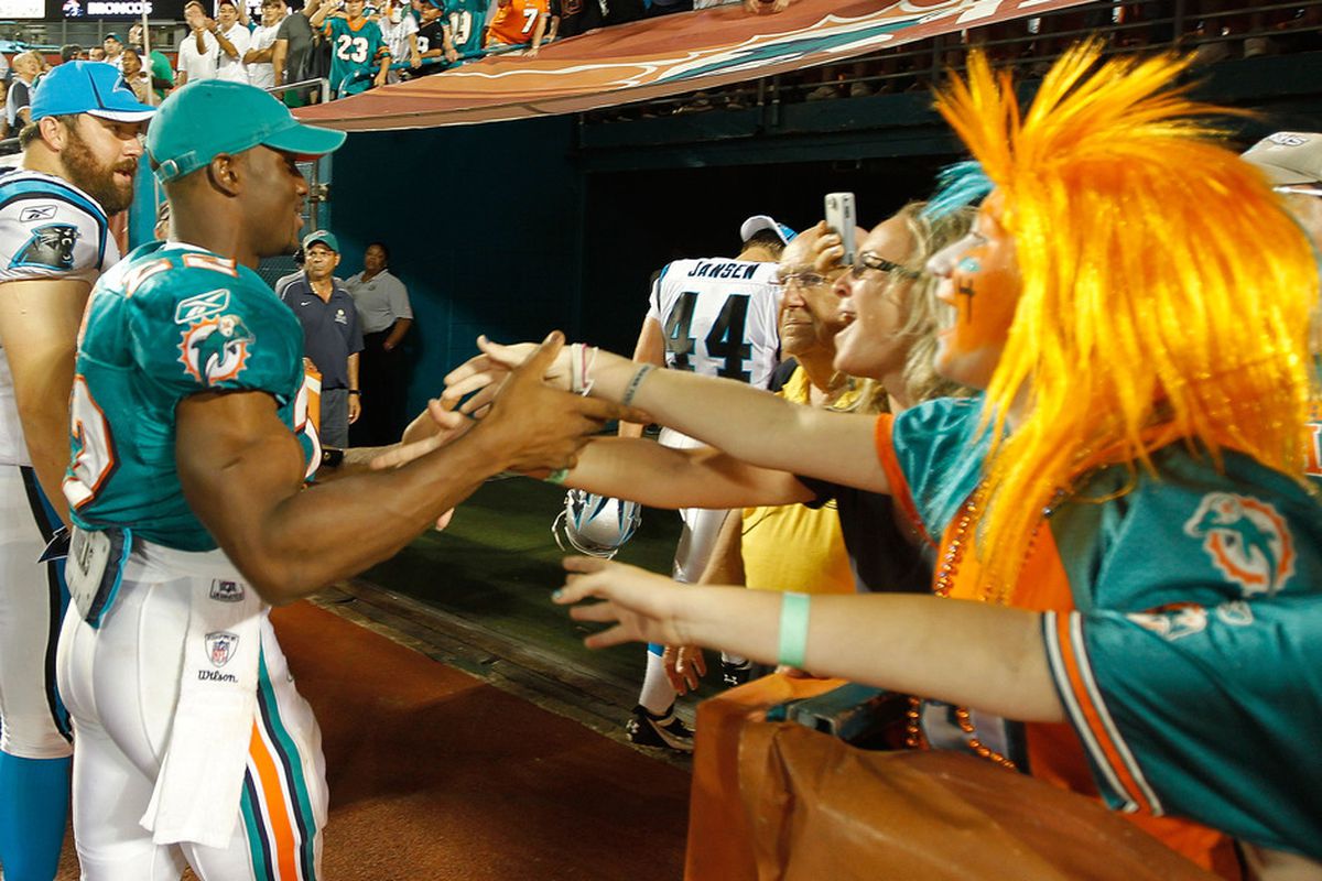 MIAMI GARDENS, FL - AUGUST 19:  Reggie Bush #22 of the Miami Dolphins greets fans after a preseason NFL game against the Carolina Panthers at Sun Life Stadium on August 19, 2011 in Miami Gardens, Florida.  (Photo by Mike Ehrmann/Getty Images)