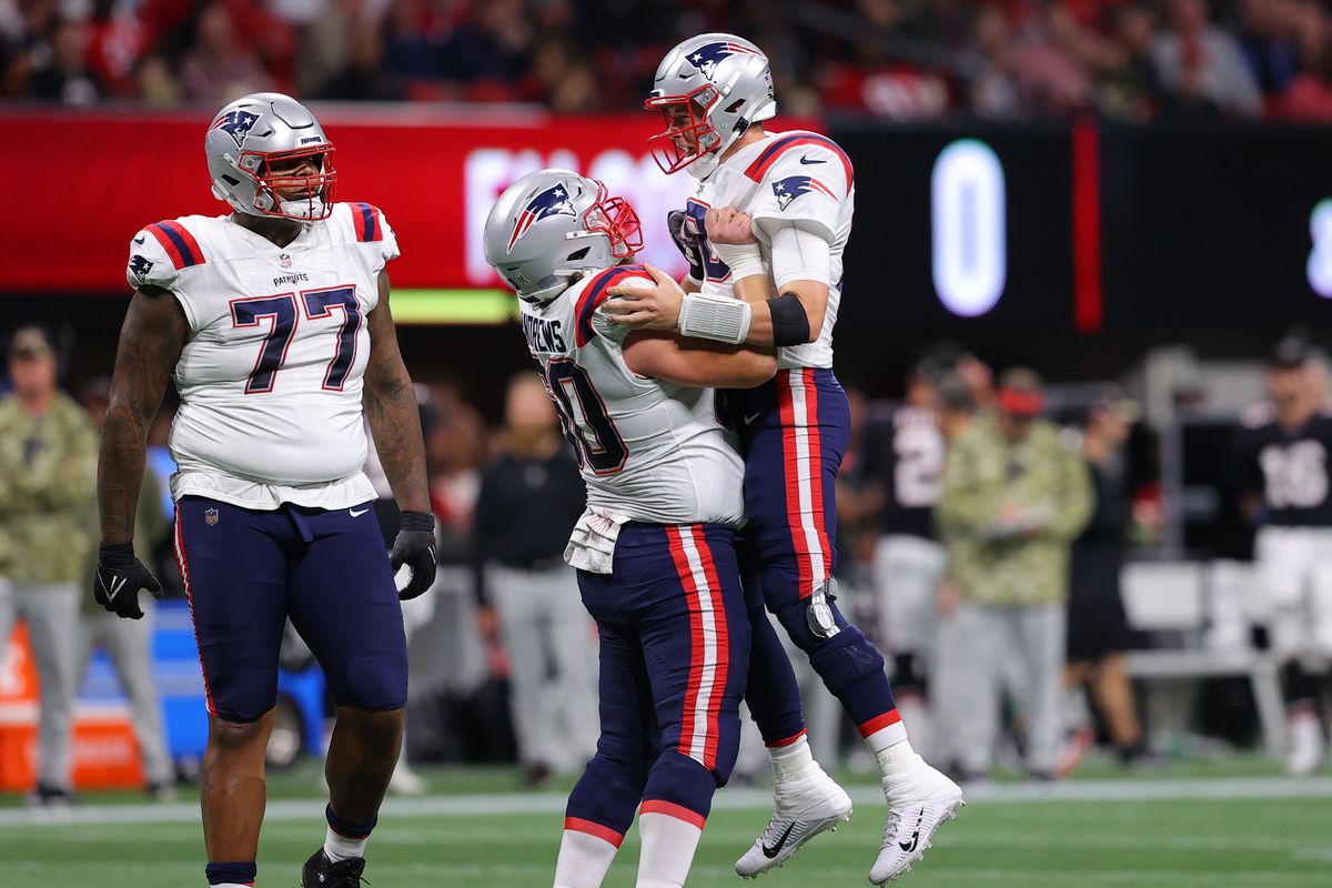 Mac Jones #10 of the New England Patriots celebrates with David Andrews #60 of the New England Patriots after a touchdown against the Atlanta Falcons in the second quarter at Mercedes-Benz Stadium on November 18, 2021 in Atlanta, Georgia.