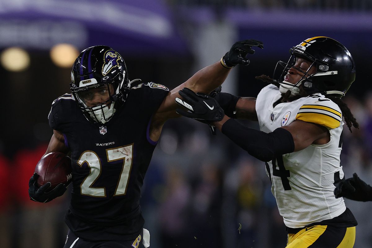 J.K. Dobbins #27 of the Baltimore Ravens stiff arms Terrell Edmunds #34 of the Pittsburgh Steelers during the second quarter at M&amp;T Bank Stadium on January 01, 2023 in Baltimore, Maryland.