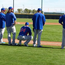 Jon Lester (34) and other pitchers wait their turn. Brian Schlitter is at Lester's left - 