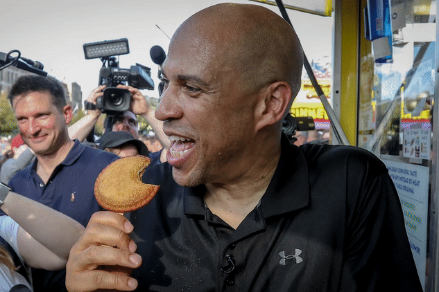 Cory Booker eating a deep fried peanut butter and jelly sandwich