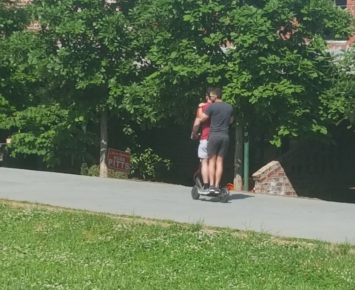 a photo of two people riding one Bird scooter on the Beltline