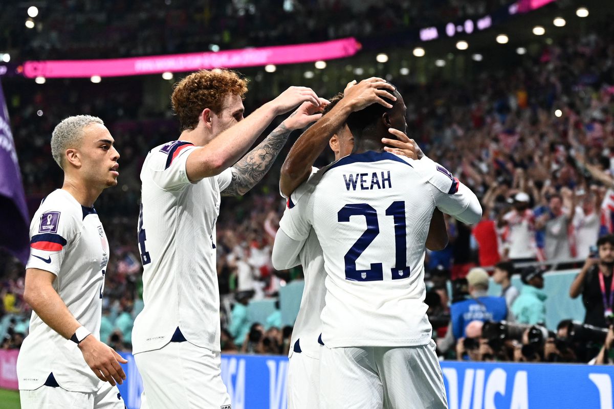 USA’s forward #21 Timothy Weah celebrates with teammates after scoring his team’s first goal during the Qatar 2022 World Cup Group B football match between USA and Wales at the Ahmad Bin Ali Stadium in Al-Rayyan, west of Doha on November 21, 2022.