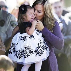 Christy Ivie, wife of U.S. Border Patrol agent Nicholas J. Ivie, comforts her 22-month-old daughter, Presley, during a graveside ceremony for agent Ivie in Spanish Fork, Thursday, Oct. 11, 2012.