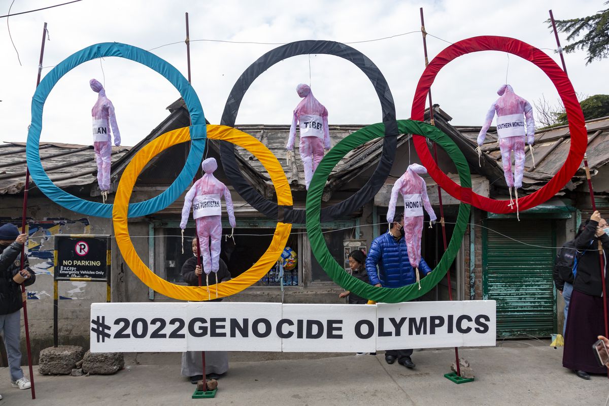 In this Feb. 3, 2021, file photo, exile Tibetans use the Olympic Rings as a prop as they hold a street protest against the holding of the 2022 Beijing Winter Olympics, in Dharmsala, India.