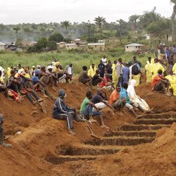 Volunteers prepare during a mass funeral for victims of heavy flooding and mudslides in Regent at a cemetery in Sierra Leone, Freetown, Thursday, Aug. 17 , 2017. The government has begun burying the 350 people killed earlier this week in mudslides in Sierra Leone's capital, and it warned Thursday of new danger from a large crack that has opened on a mountainside where residents were told to evacuate.