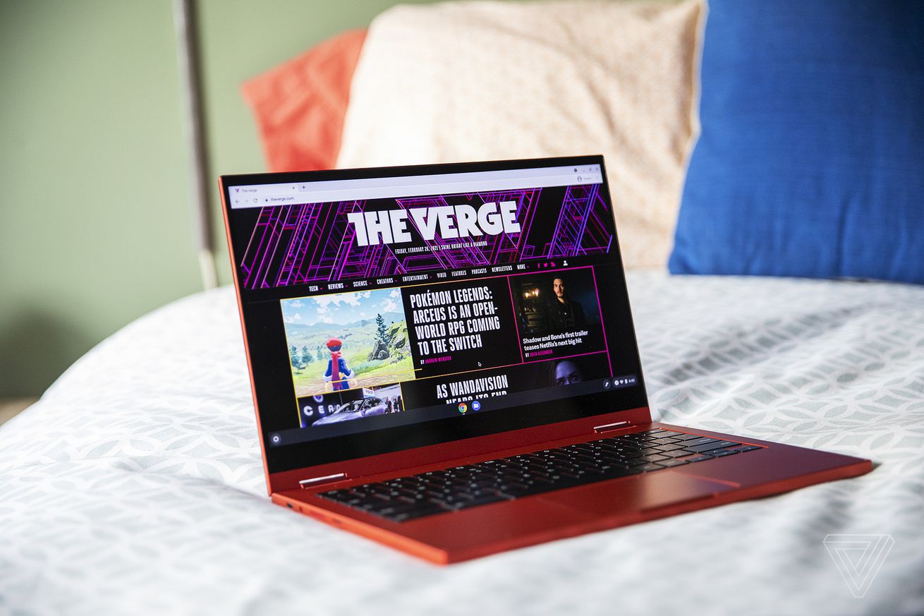 The Samsung Galaxy Chromebook open, tilted slightly to the right on the corner of a bed.  The screen displays MovieBeat home page.