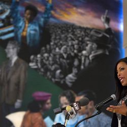 Ilyasah Shabazz, daughter of Malcolm X, speaks about her father and family with a mural depicting their lives behind her Saturday, Feb. 21, 2015, as family, activists, actors, and politicians remembered the civil rights leader during a ceremony at the New York site in Harlem where he was killed 50 years ago today. 