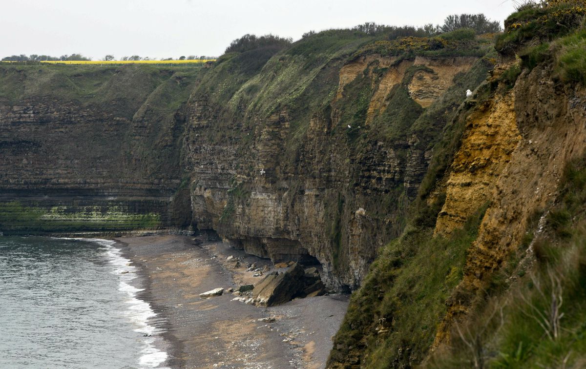 In this May 1, 2019, photo, the cliffside of Pointe du Hoc overlooking Omaha Beach in Saint-Pierre-du-Mont, Normandy, France. On June 6, 1944, U.S. Rangers scaled the coastal cliffs to capture a German gun battery. (AP Photo/Virginia Mayo)