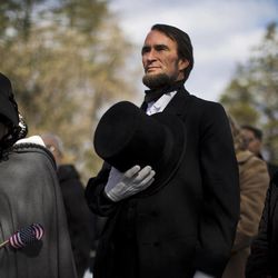John Voehl portraying President Abraham Lincoln,  covers his hart during a ceremony commemorating the 150th anniversary of the dedication of the Soldiers’ National Cemetery and President Abraham Lincoln's Gettysburg Address, Tuesday, Nov. 19, 2013, in Gettysburg, Pa. Lincoln's speech was first delivered in Gettysburg nearly five months after the major battle that left tens of thousands of men wounded, dead or missing.  