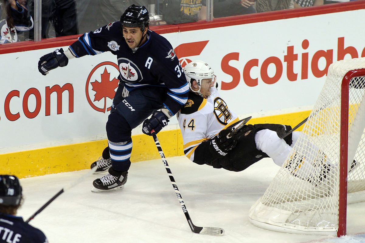 WINNIPEG, CANADA - DECEMBER 6: Dustin Byfuglien #33 of the Winnipeg Jets and Dennis Seidenberg #44 of the Boston Bruins collide in NHL action at the MTS Centre on December 6, 2011 in Winnipeg, Manitoba, Canada. (Photo by Marianne Helm/Getty Images)