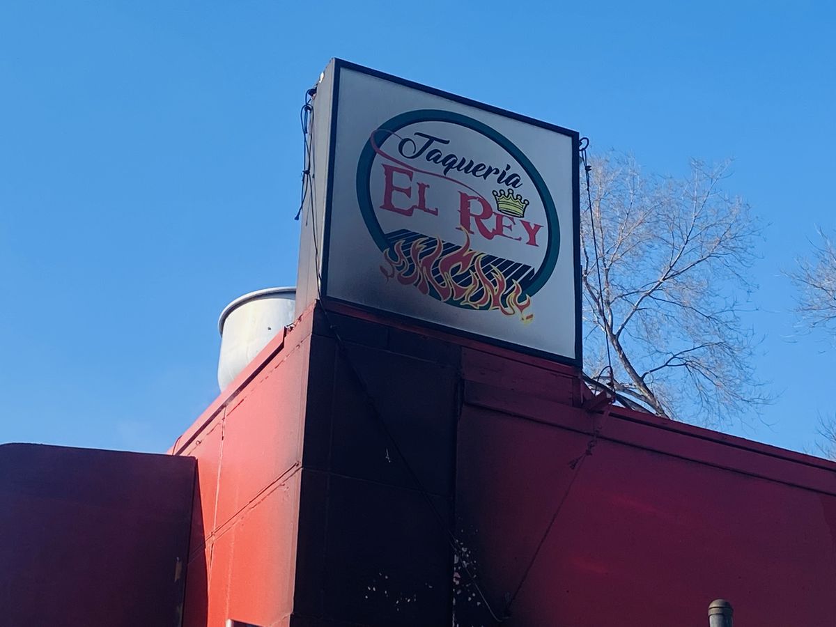 A sign of Taqueria El Rey, with apparent fire damage, on top of the building.