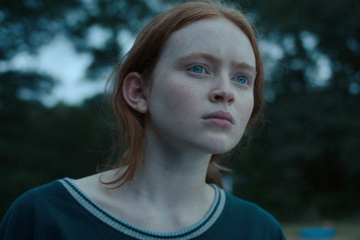 Stranger Things - Max Mayfield, portrayed by Sadie Sink. A pale young woman with red hair, she looks into the distance with a confused but intent expression.
