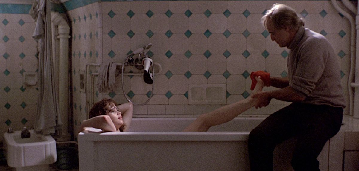 Maria Schneider lies in a bathtub as Marlon Brando washes her feet in Last Tango in Paris