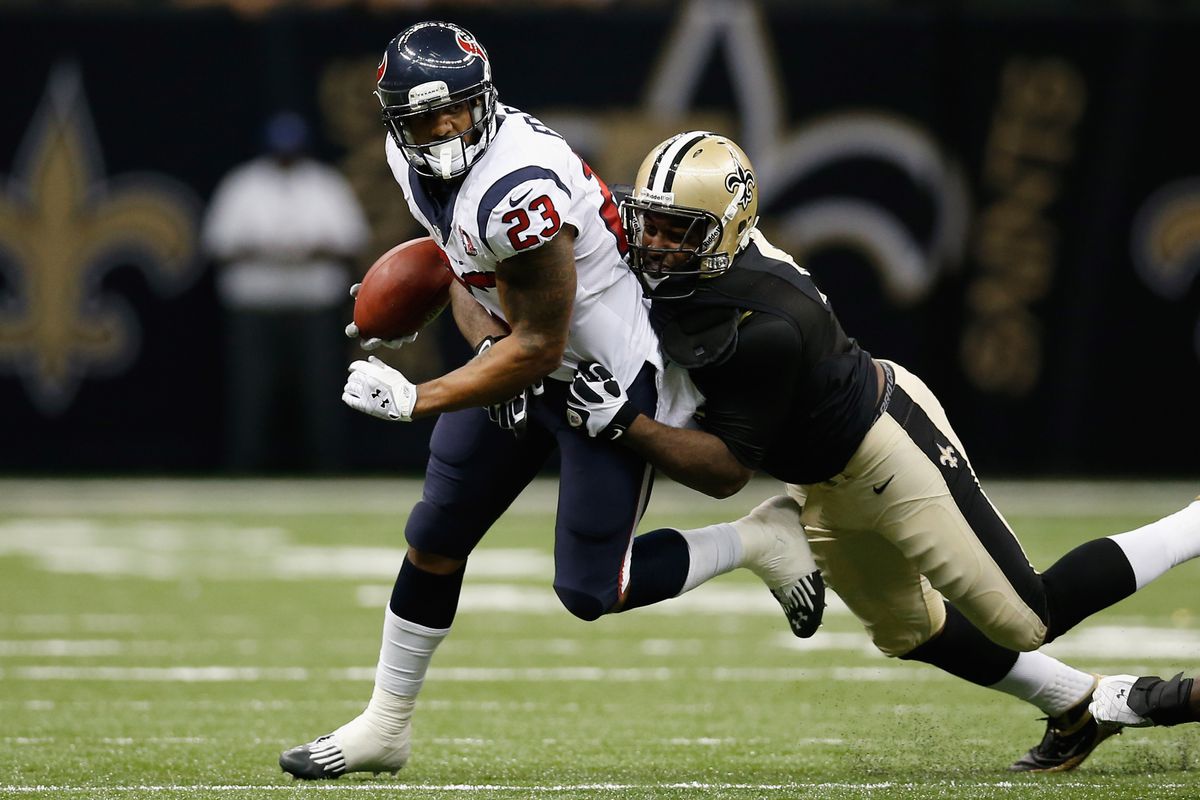 NEW ORLEANS, LA - AUGUST 25:   Arian Foster #23 of the Houston Texans is tackled by  Cameron Jordan #94 of the New Orleans Saints at the Mercedes-Benz Superdome on August 25, 2012 in New Orleans, Louisiana.  (Photo by Chris Graythen/Getty Images)