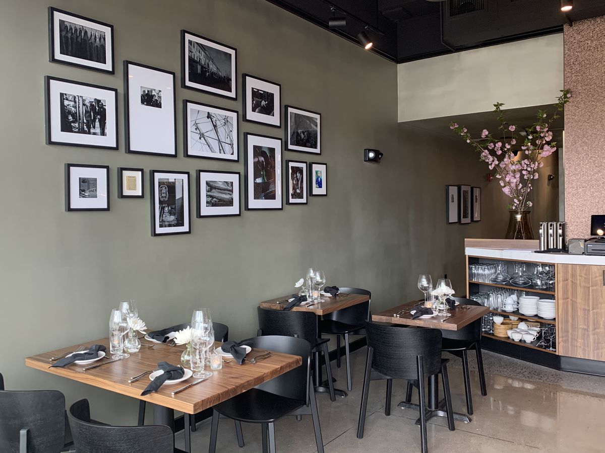 Bistro tables beneath a wall with a photo collage